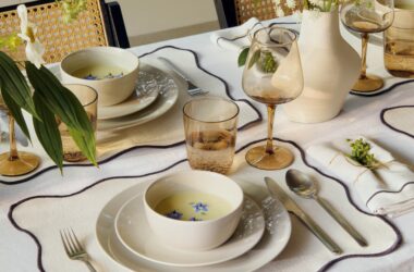 et a fresh and modern aesthetic guide the new spring season. H&M HOME invites for a journey of inspiration and bright transformation, presenting a new spring season with a clean-cut look, from crisp whites to sparkling greens. Textiles with an array of prints including cushion covers, blankets to sculptural vases and long-lasting bigger furniture pieces for brighter and airy days ahead. The new spring collection launches in stores and online at hm.com/home 4th January 2024. H&M HOME introduces a curated and modern season of a clean colour palette, offering both a mix of patterns as well as block colours ranging from green, lime, pear to juniper and sage hues, to crisp white, sunny yellow, muted mustard and soft beige tones. To inject instant spring freshness, make your living room the focal point of this bright new season. Use our new textured cream white rug as the foundation of your spring canvas, styling with a mix of new cushion covers including quilted, geometrically patterned and floral print ones for the ultimate impact, alongside sculptural vases in green or white. The new cool grey tray with wave edges adds a lovely final touch alongside ribbed block candles that come in a variety of shades, including blue, tan and green. For spring dining, the H&M HOME iconic safari dining chair makes for the perfect starting point to create a stylish springtime table. Use a green tablecloth for a pop of colour, or simply go with a classic soft white version. Less is more this season with slightly rounded cream white mid-sized plates, which come with matching big plates, deep plates and mid-sized bowls. Wine and water glasses in an on-trend see-through mocha hue create a stylish effect. The scalloped placemat with black edges and matching napkin are a perfect final addition. Bedding is colourful this season, with a tartan-inspired chequered set in pink, white and green with frill-edged pillow cases. Add a soft lime green blanket and the textured cream white rug here too. Muted stripes in mocha and blue green alongside block colours from the same colour palette make part of the spring bathroom styles. Add woven laundry baskets in cream beige or blue green and switch it up to this season’s new marble hooks and knobs for a tasteful look. Key pieces Elevate your spring sofa with new textiles — block colour quilted cushion covers in a range of colours from muted mustard, soothing green to fresh white to blankets in lime or green. Geometric vases in various sizes and footed bowls adding a soft touch of elegance. Block candles in beige or green for chic décor details, always placed on a tray. For spring dining, textile cream white placemats with black scalloped edges, alongside mocha-hue glassware for drinks. Pastels and print are very much still in demand – dress your bed in a pink, white and green patterned bed set with frills. Stripes and muted block colours blue to mocha and coffee set the tone for towels.