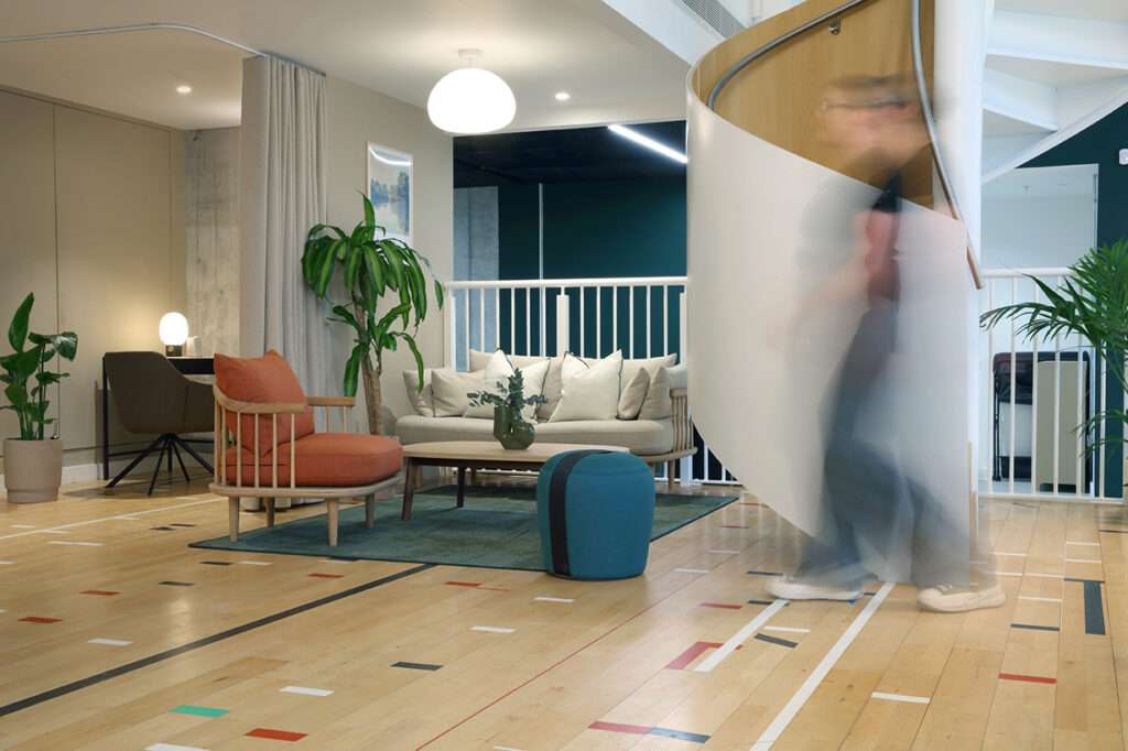 Elevated platform opposite entrance made from re-used Junckers recycled gym flooring, adjacent to stair