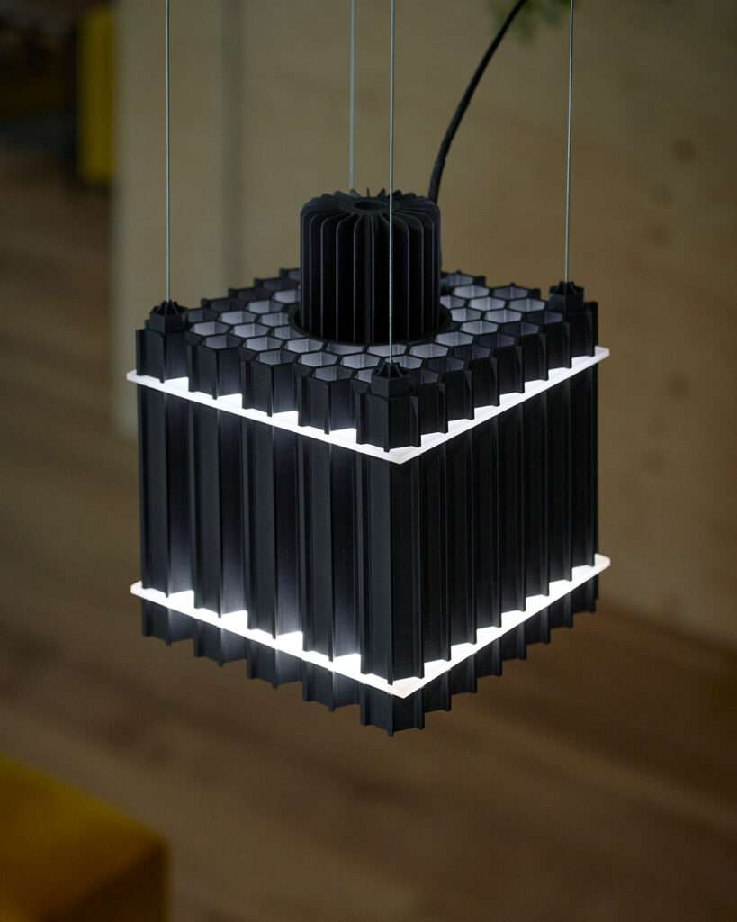 The fusion of art, design, and light takes on a bold form in Grid Extrusion, a collaboration between two visionary artists, Juliana Campos and Aster Verrier. Inspired by the complexities of machinery and the directional qualities of light, this striking piece embraces a raw, industrial aesthetic that turns functionality into a work of art.