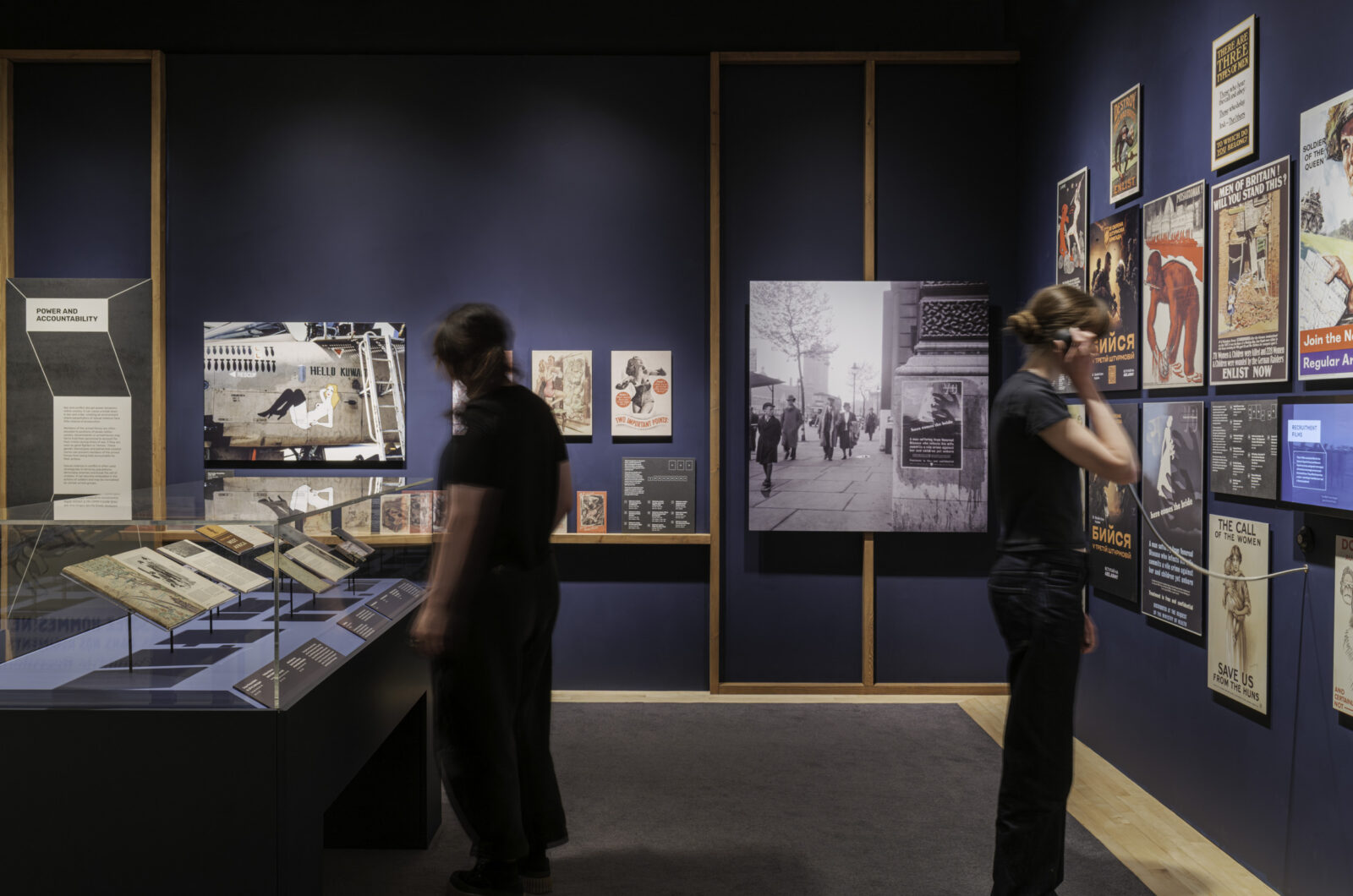 The exhibition design features a progression of colour from darker tone of blue to lighter, more neutral colours