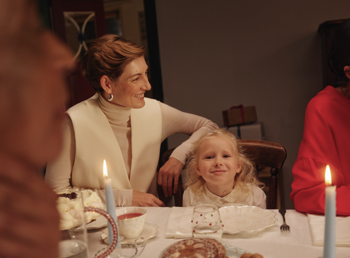 Family celebrating Christmas at a festive holiday dining table with decorations and seasonal dishes