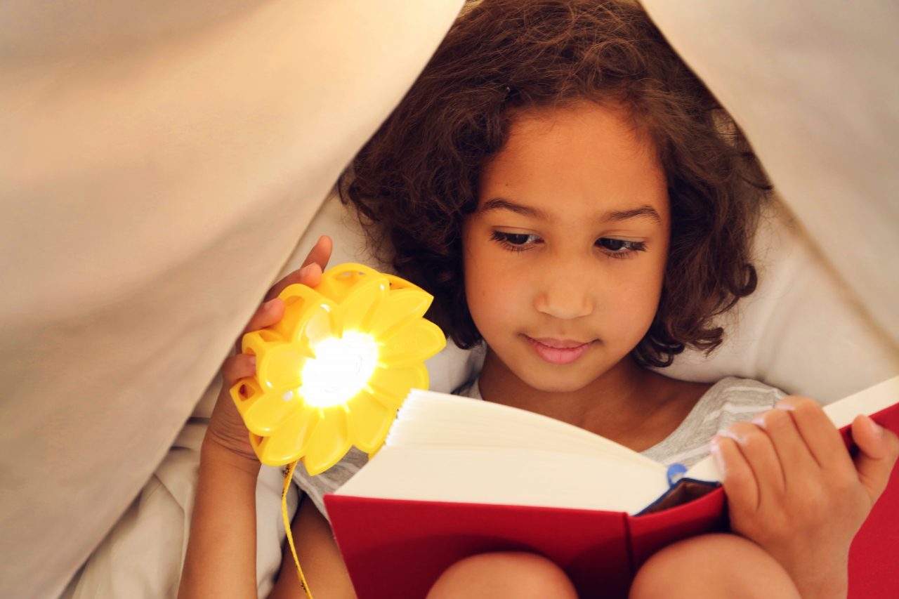 Little girl reading with Little Sun Original,© Franziska Russo