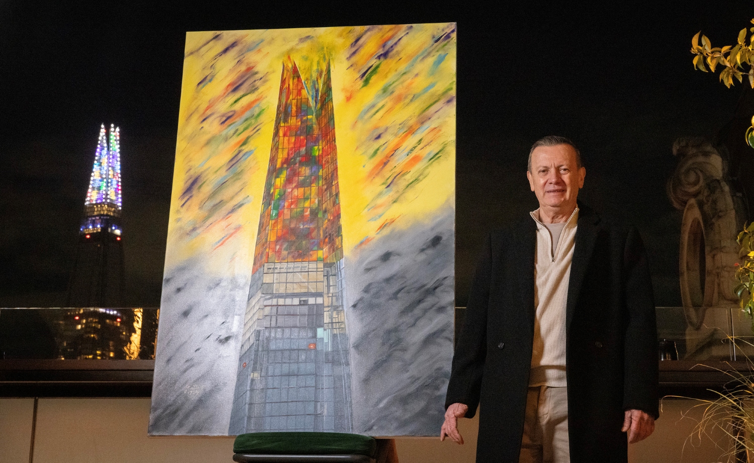 Artist Gustavo Zuluaga Villegas poses with his painting of The Shard in London at the switch-on of this year’s Christmas light display