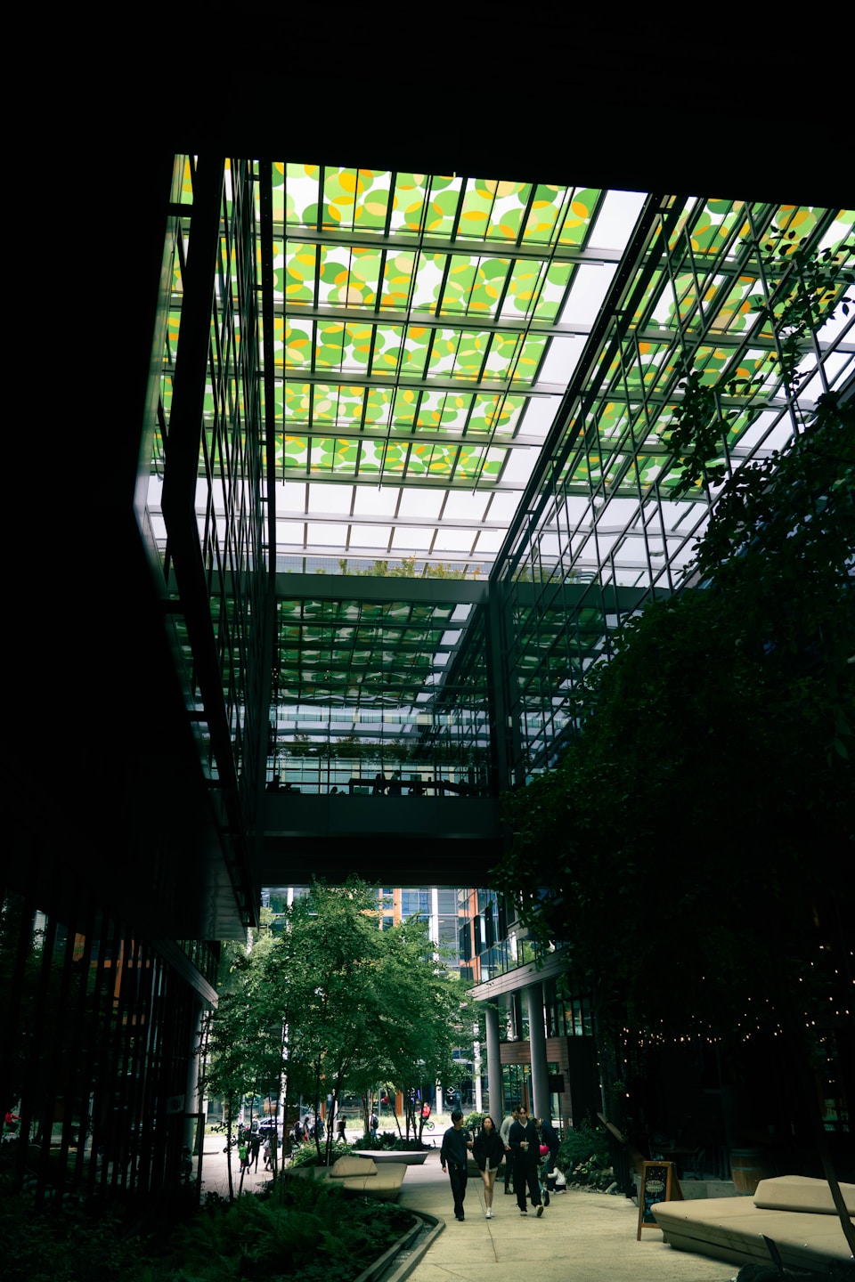 Modern building with a green glass ceiling and trees