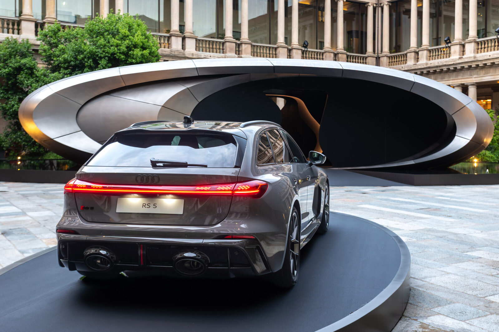Rear view of the Audi RS 5 positioned on an display platform in front of the installation “Origin”.