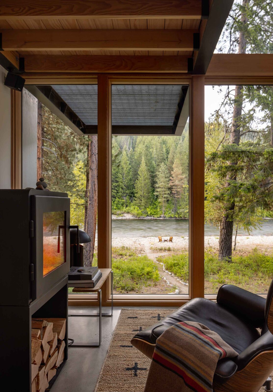 Wenatchee River Cabin by Wittman Estes. View out of the living room windows with fireplace.